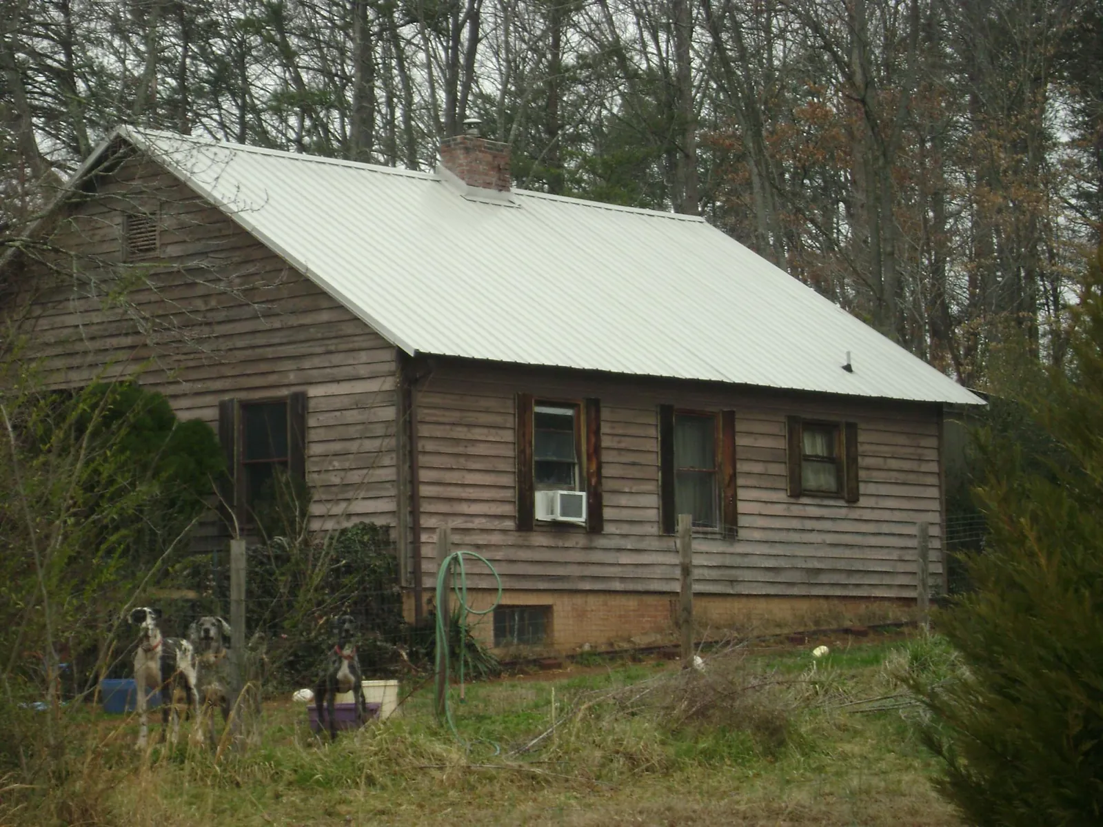 White metal roof on an old wood sided farmhouse, from a Metal Roof Installation job in Riceville
